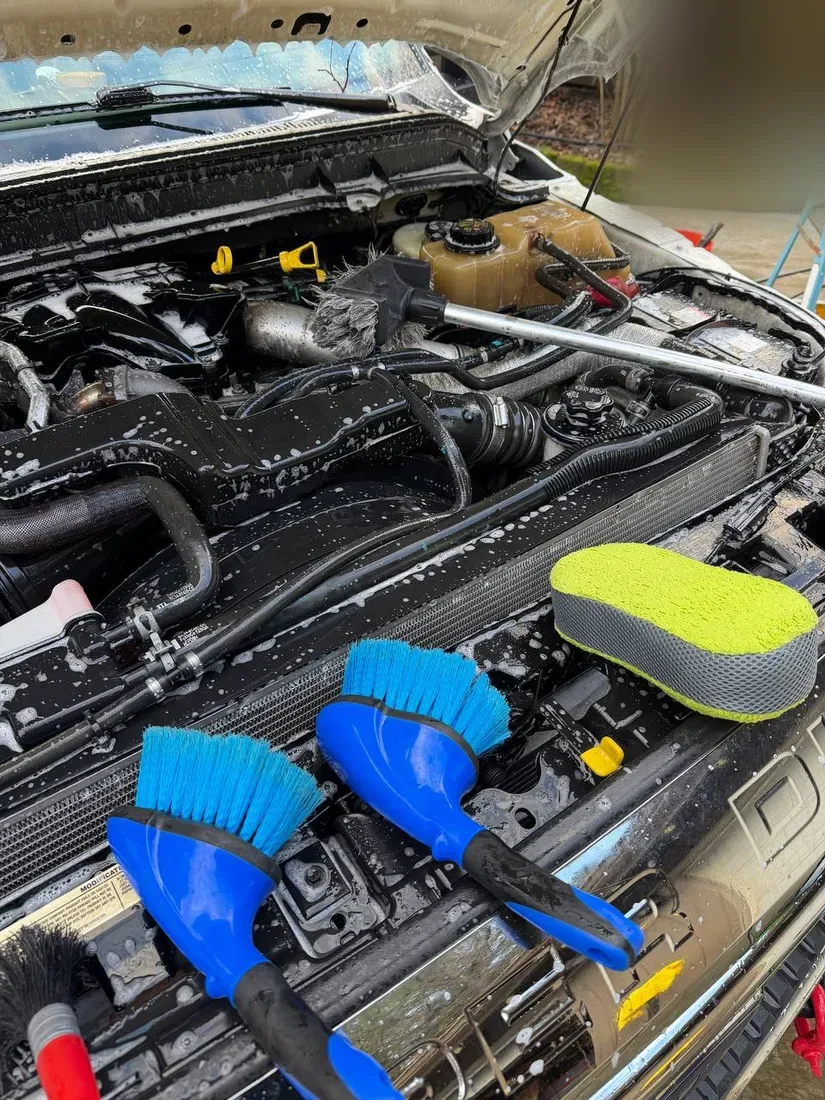 Engine bay being degreased with brushes